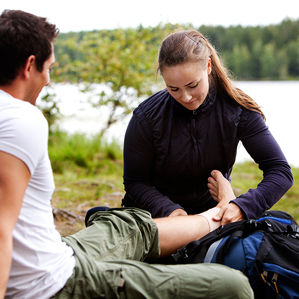 Dame som bandasjerer fot