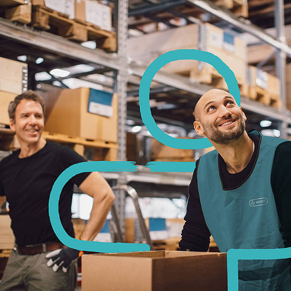 To smilende ansatte på lager