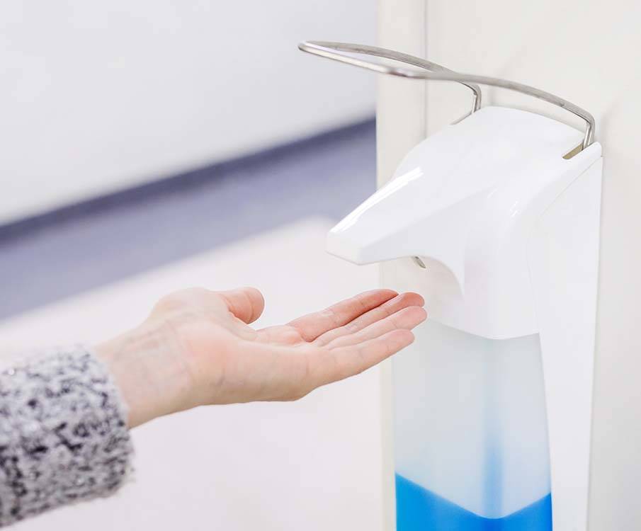 person som bruker antibac fra dispenser