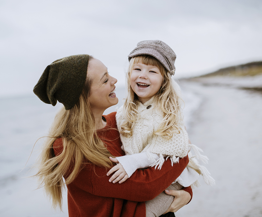 smilende mor og datter på stranden